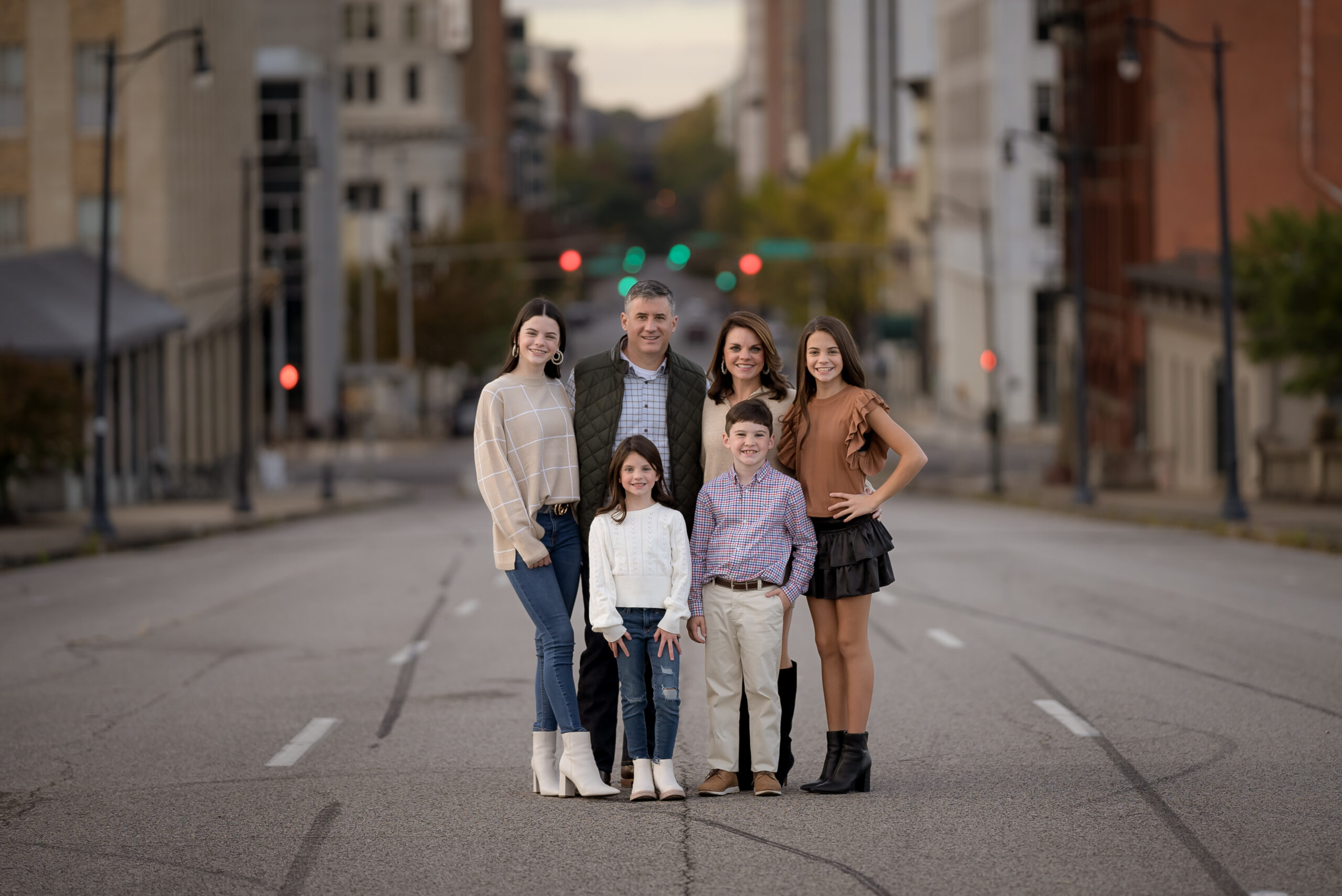 A family posing for a picture in the middle of an empty street.