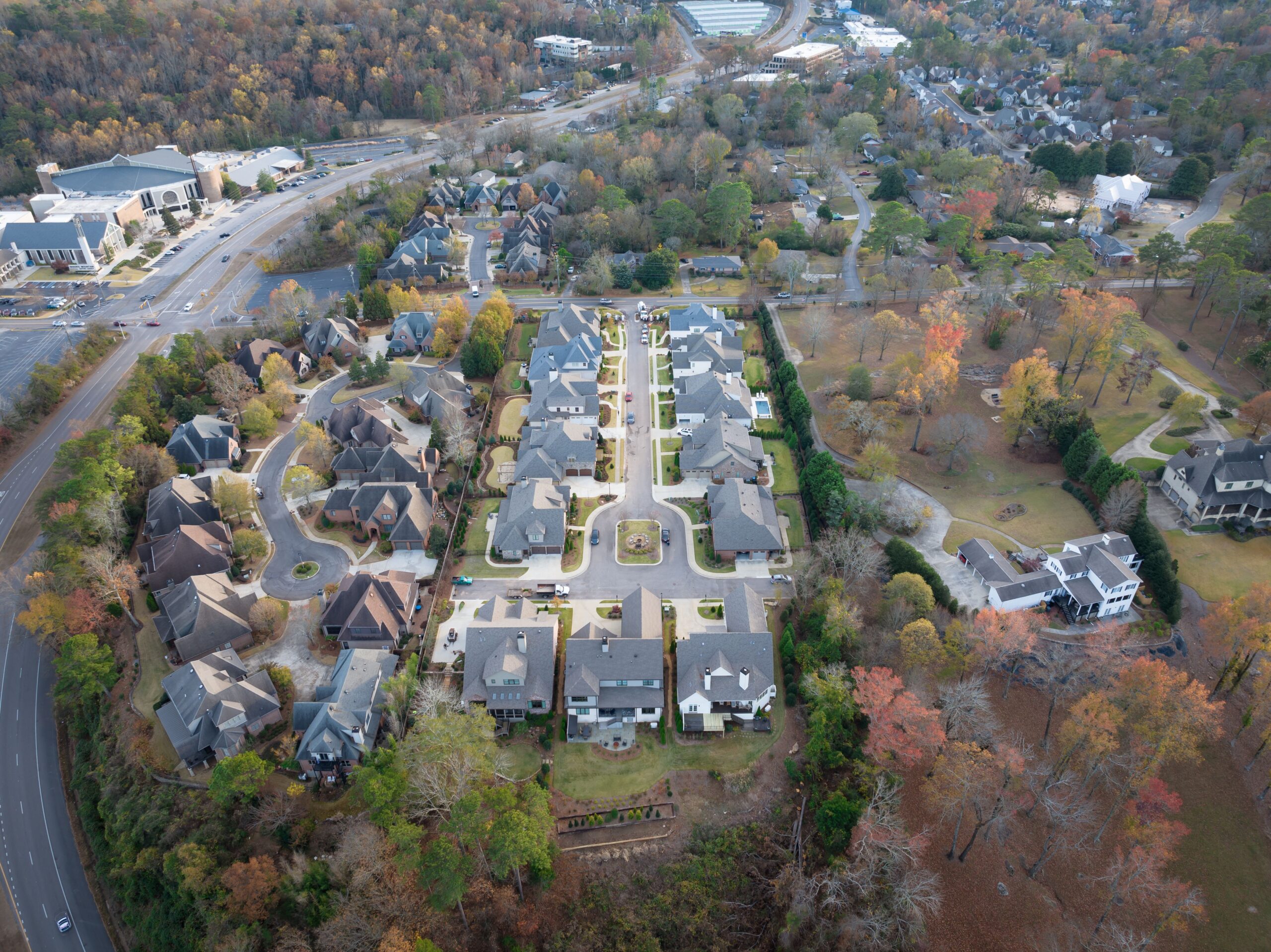 A view of houses from above with trees in the background.