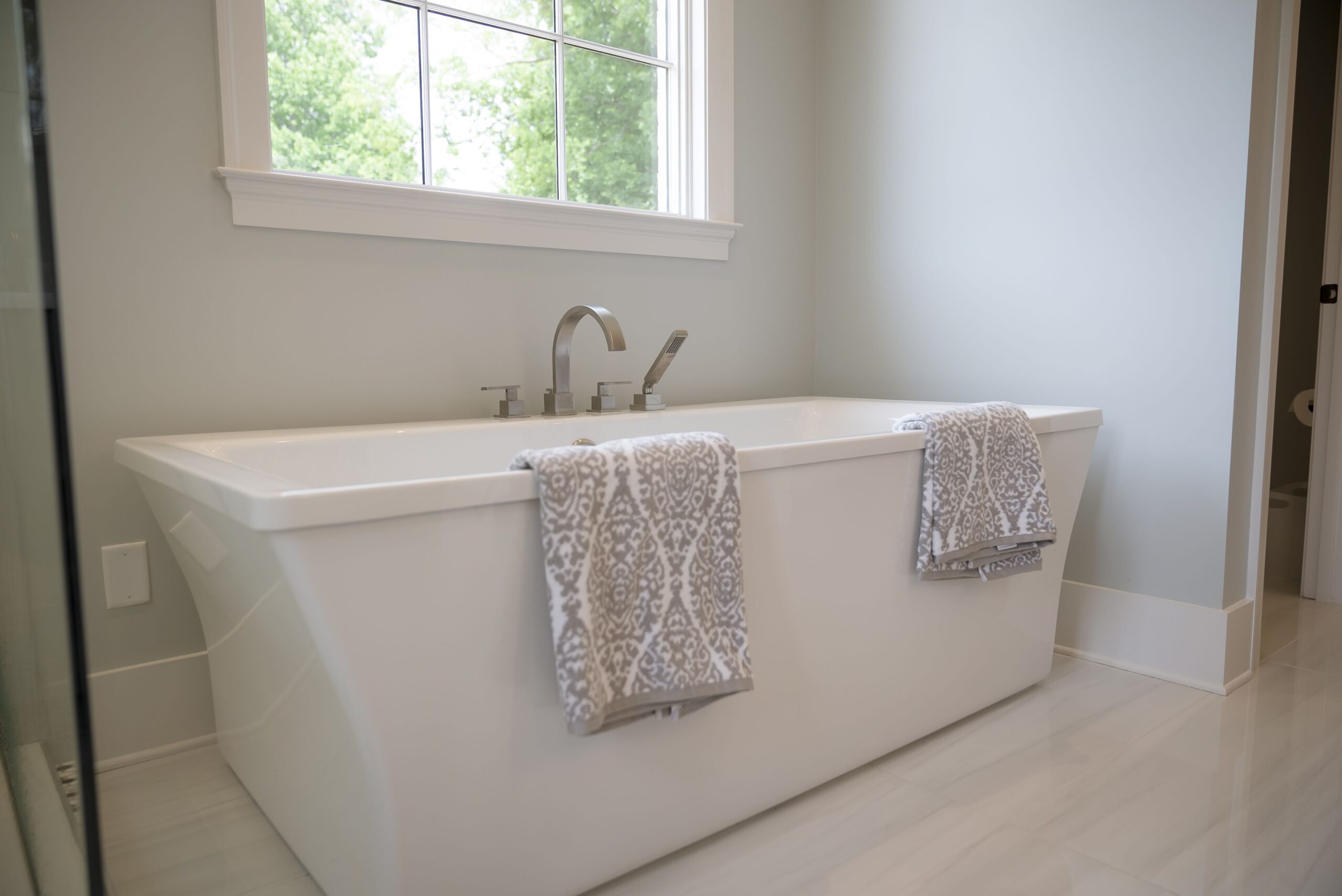 A white bath tub sitting in the middle of a bathroom.