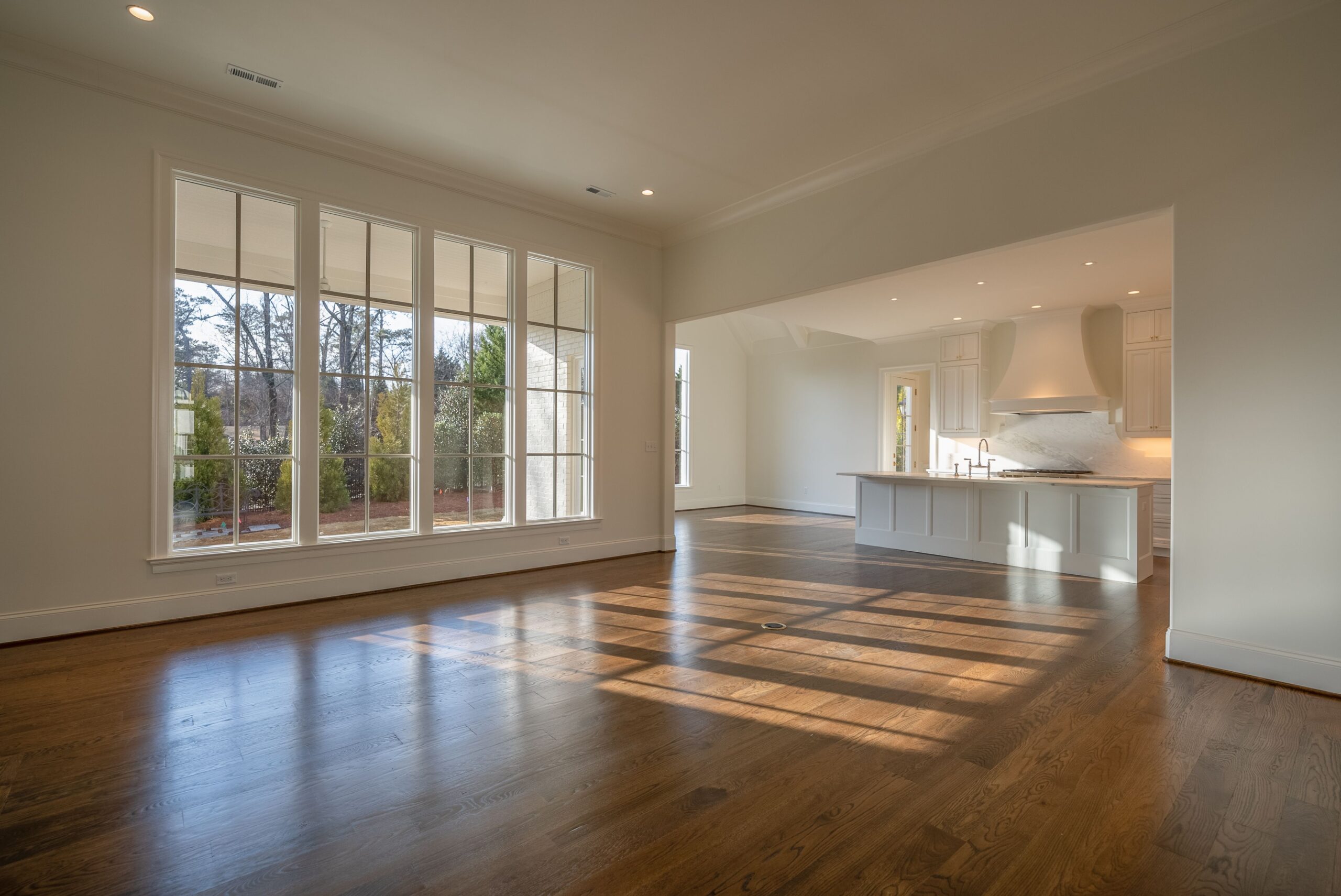 A large open floor plan with wood floors and white walls.