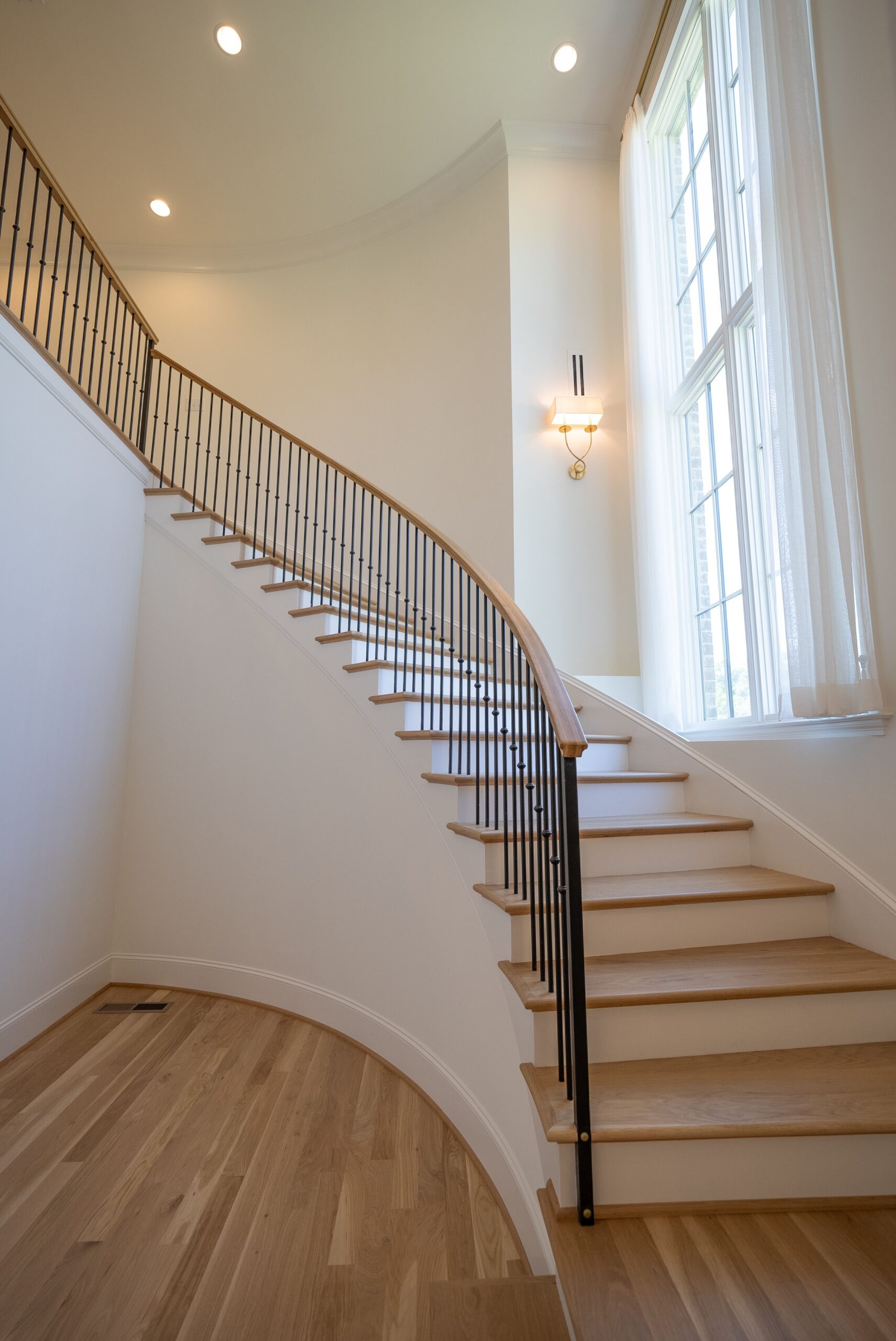 A staircase with white walls and wooden floors.
