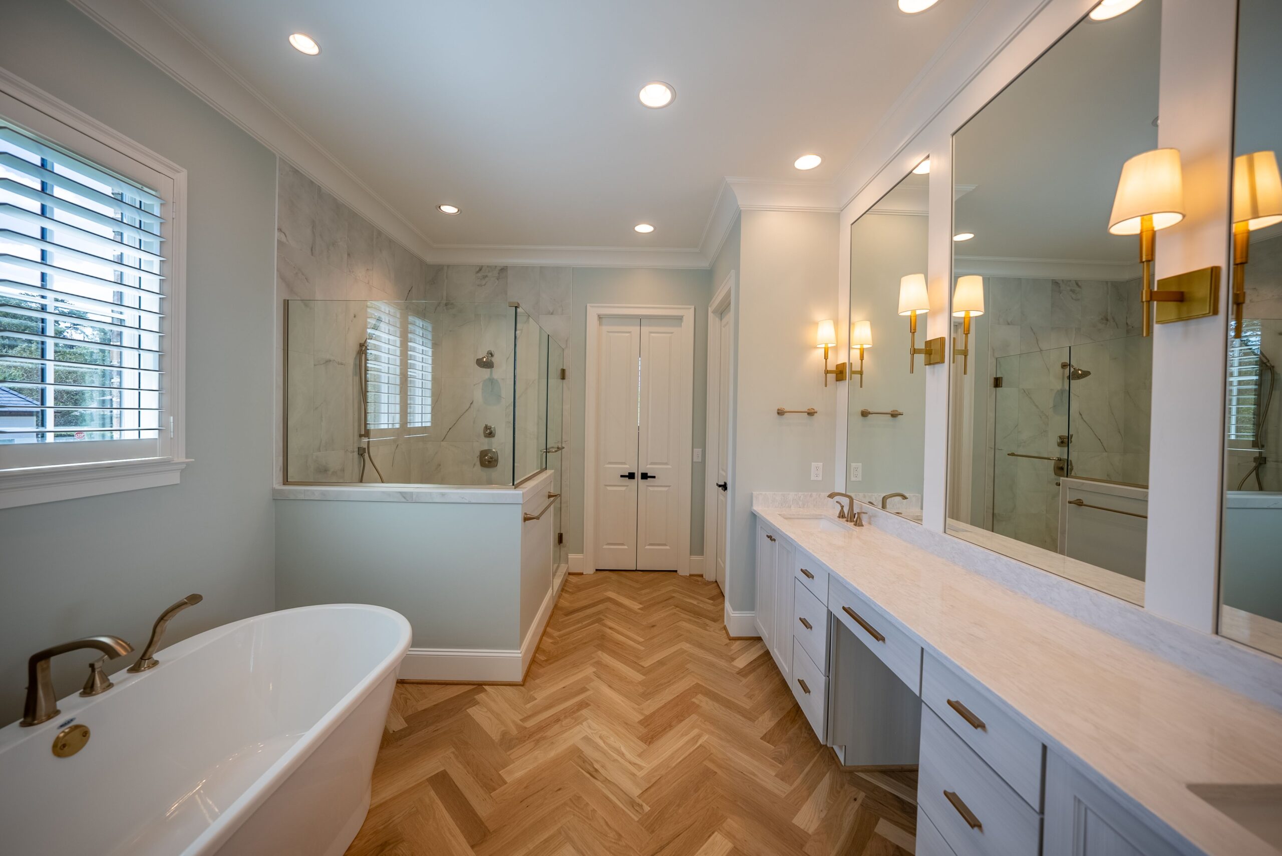 A bathroom with a tub, sink and mirror.