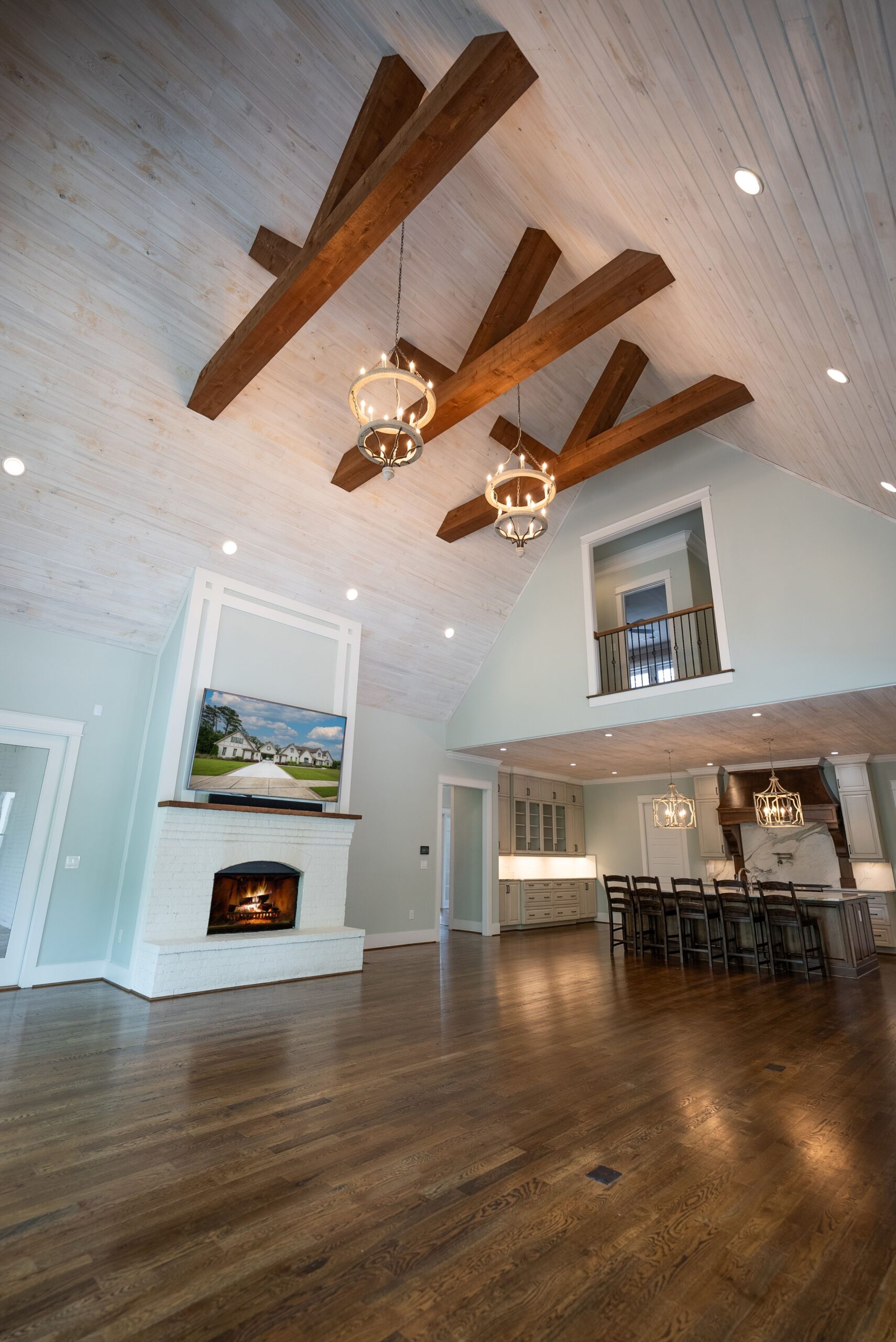 A large open living room with wood beams and fireplace.